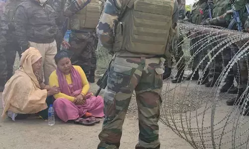 Photo of  Wife of a missing Meitei man sits in front of barbed