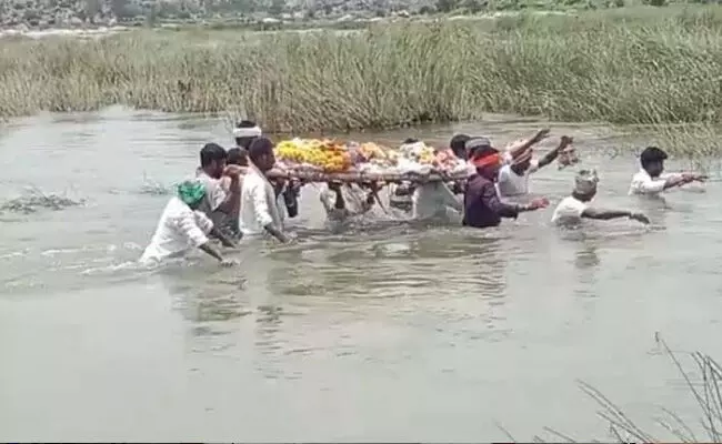 ರಾಯಚೂರು |ಮುಕುಂದ ಗ್ರಾಮದಲ್ಲಿ ಮೃತರ ಅಂತ್ಯ ಸಂಸ್ಕಾರ ನಡೆಸಲು ಹರಿಯುವ ನದಿ ದಾಟಿ ಹೋಗುವ ಪರಿಸ್ಥಿತಿ : ಸೇತುವೆ ನಿರ್ಮಿಸಲು ಒತ್ತಾಯ ರಾಯಚೂರು |ಮುಕುಂದ ಗ್ರಾಮದಲ್ಲಿ ಮೃತರ ಅಂತ್ಯ ಸಂಸ್ಕಾರ ನಡೆಸಲು ಹರಿಯುವ ನದಿ ದಾಟಿ ಹೋಗುವ ಪರಿಸ್ಥಿತಿ : ಸೇತುವೆ ನಿರ್ಮಿಸಲು ಒತ್ತಾಯ