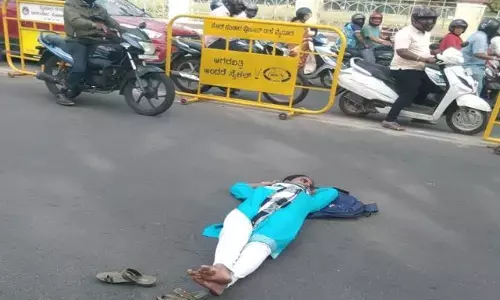 ಮೈಸೂರು | ಅಂಕಪಟ್ಟಿಗಾಗಿ ರಸ್ತೆಯಲ್ಲಿ ಮಲಗಿ ವಿದ್ಯಾರ್ಥಿನಿ ಧರಣಿ