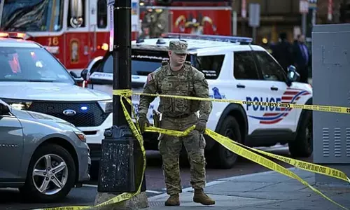 A National Guard soldier secures the area with crime scene tape after a shooting in downtown Washington, DC, on Nov.26, 2025.