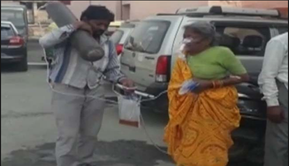 ಅನಾರೋಗ್ಯ ಪೀಡಿತ ತಾಯಿಯ ಆಕ್ಸಿಜನ್ ಸಿಲಿಂಡರನ್ನು ಹೆಗಲಲ್ಲಿ ಹೊತ್ತು ನಿಂತ ಪುತ್ರ!