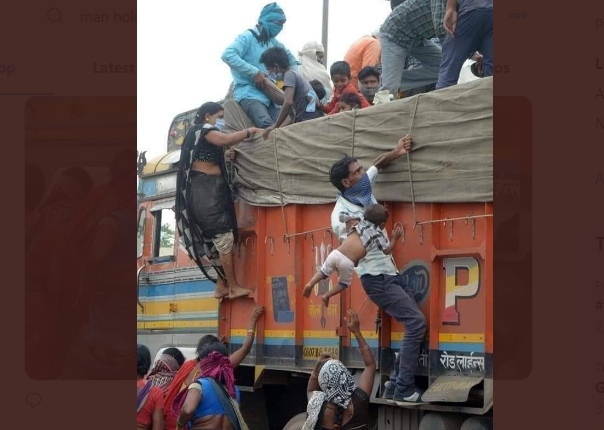 ಮಗುವನ್ನು ಒಂದು ಕೈಯಲ್ಲಿ ಹಿಡಿದು ಟ್ರಕ್ ಹತ್ತಲು ಪರದಾಡುತ್ತಿರುವ ಕಾರ್ಮಿಕ