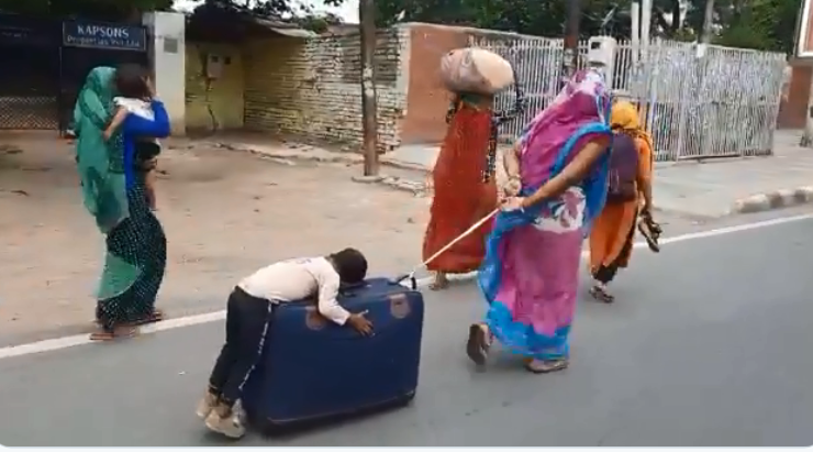 ತಾಯಿ ಎಳೆದುಕೊಂಡು ಹೋಗುತ್ತಿದ್ದ ಸೂಟ್ ಕೇಸ್ ಮೇಲೆ ಮಲಗಿದ ಬಾಲಕ: ಫೋಟೊ ವೈರಲ್