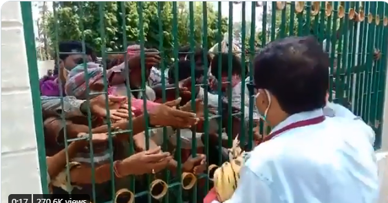 ಕಬ್ಬಿಣದ ಗೇಟುಗಳ ನಡುವಿನಿಂದ ಬಾಳೆಹಣ್ಣು ವಿತರಣೆ: ಹಸಿವಿನಿಂದ ಕಂಗಾಲಾಗಿ ಮುಗಿಬಿದ್ದ ವಲಸೆ ಕಾರ್ಮಿಕರು