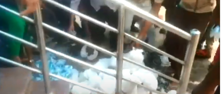 ಪೊಟ್ಟಣಗಳನ್ನು ನೆಲದಲ್ಲಿ ಇಟ್ಟು ಹೋದ ಅಧಿಕಾರಿಗಳು: ಆಹಾರಕ್ಕಾಗಿ ಮುಗಿಬಿದ್ದು ತಳ್ಳಾಡಿಕೊಂಡ ಕಾರ್ಮಿಕರು