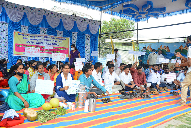 ತುಮಕೂರು: ಸೇವಾ ಭದ್ರತೆಗೆ ಒತ್ತಾಯಿಸಿ ಬೂಟ್‍ಪಾಲಿಶ್ ಮಾಡುವ ಮೂಲಕ ಅತಿಥಿ ಉಪನ್ಯಾಸಕರ ಧರಣಿ