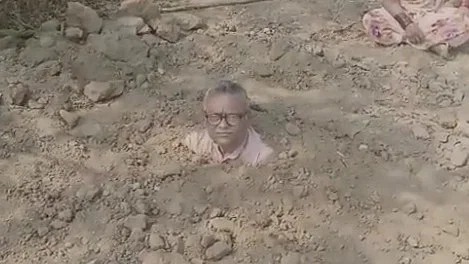 ಭೂ ಸ್ವಾಧೀನ ಪತ್ರಕ್ಕಾಗಿ ಮಣ್ಣಿನಲ್ಲಿ ಹೂತುಕೊಂಡು ಪ್ರತಿಭಟಿಸಿದ ರೈತ